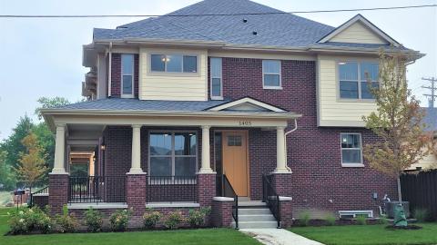 A brick townhouse with a large front porch