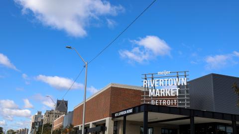 A grocery store with the Detroit skyline and blue sky