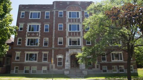 An older four-story brick apartment building