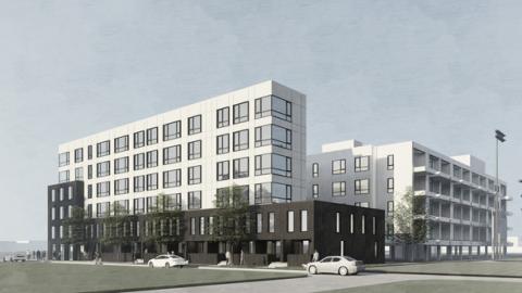 A white apartment building along the corner of two streets