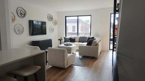 A new apartment with light furniture and a stairway to the right