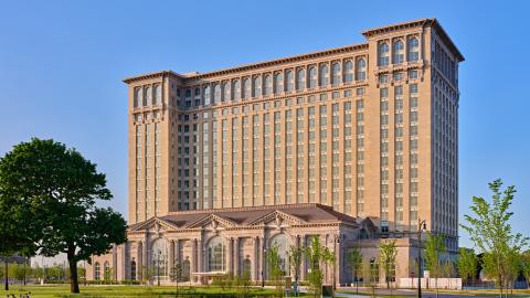 A 13-story classic train station with a park in front of it